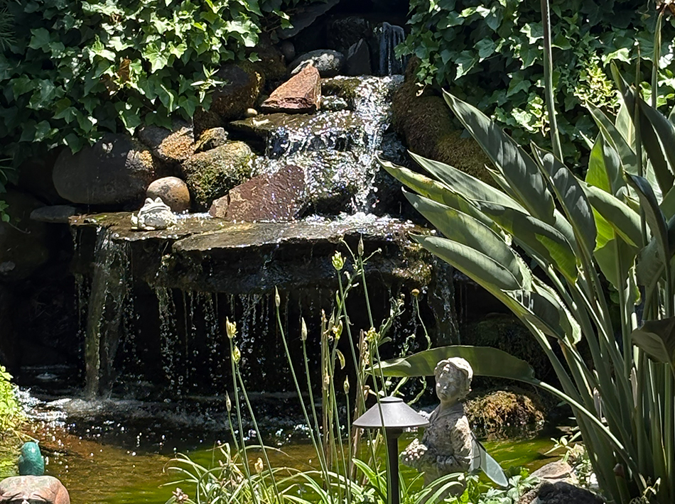Backyard waterfall flowing through natural stone